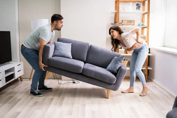 Person Lifting Heavy Furniture Couch Having Back Injury — Stock Photo, Image