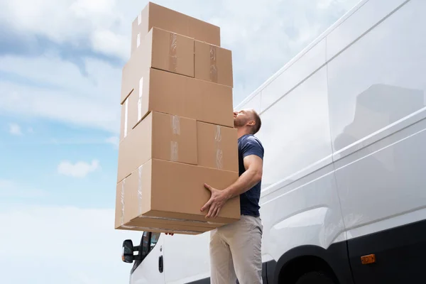 Movers Carrying Heavy Large Box Stack Near Truck