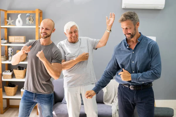 Tres Hombres Generación Bailando Haciendo Ejercicio Con Abuelo Mayor —  Fotos de Stock