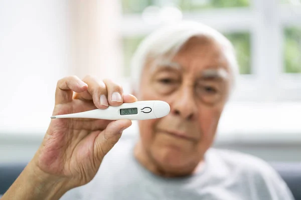 Beteg Senior Man Mutatja Hőmérséklet Télen — Stock Fotó