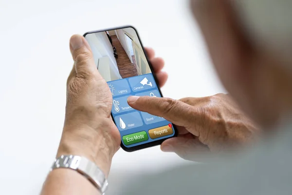Elder Using Home Heating Control Alarm Automation — стоковое фото