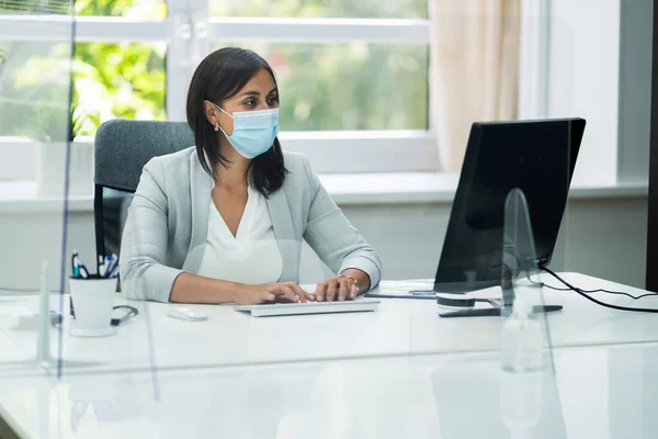 Employee In Office Social Distancing Using Sneeze Guard And Face Mask