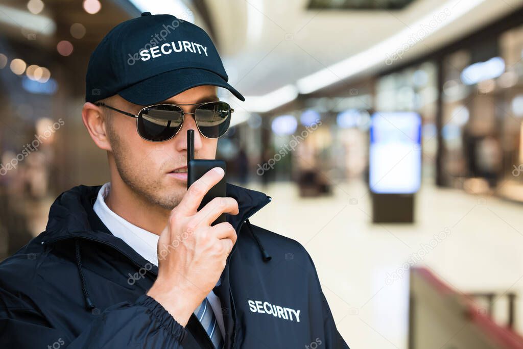 Security Guard Using Walkie Talkie In Shopping Mall