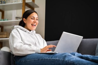 Women Using Computer Laptop On Couch Or Sofa clipart