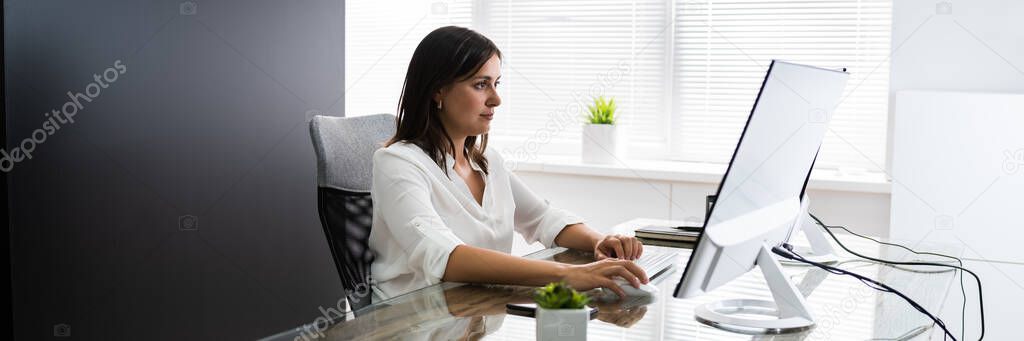 Confident Business Woman At Office Desk Working