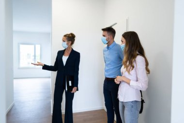 Mutlu çift emlakçı maskeli yeni bir ev alıyor.