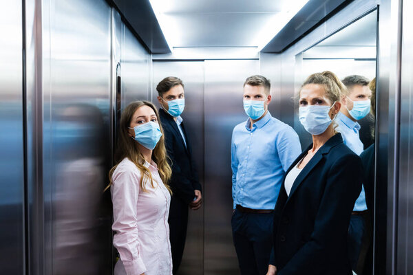 Группа людей в лифте в масках для лица
