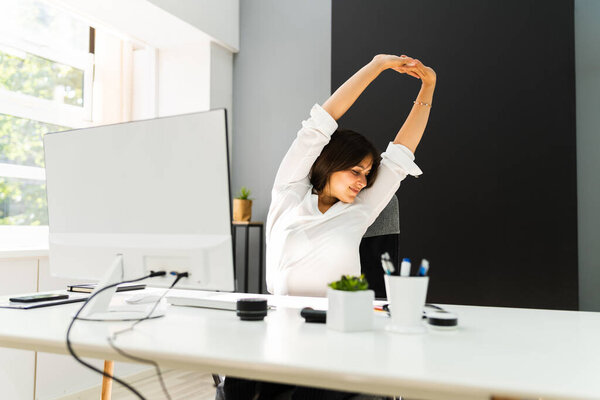 Woman Stretches At Office Desk. Stretch Exercise On Chair