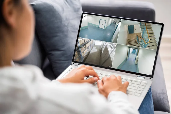 Person Using Home Security System On Laptop Computer