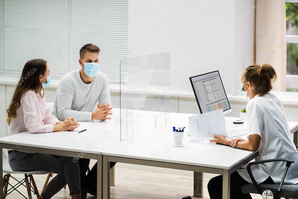 Doctor Talking To Patient At Meeting About Pregnancy With Face Masks