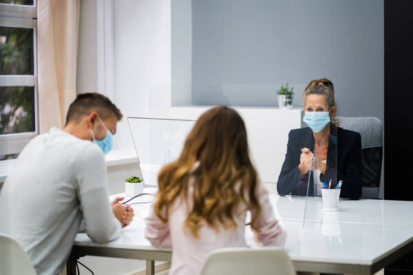 Young Family Couple Meeting Consultant Or Lawyer With Face Masks