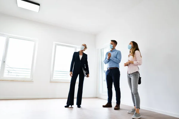 Casal Feliz Comprando Nova Casa Com Realtor Vestindo Máscaras — Fotografia de Stock