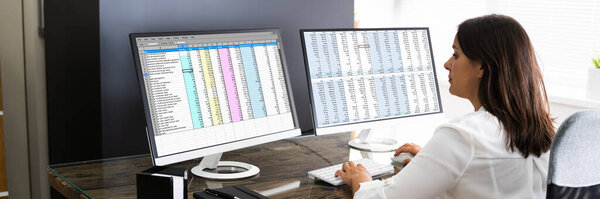 Аналитик, работающий с таблицами Бизнес-данные на компьютере