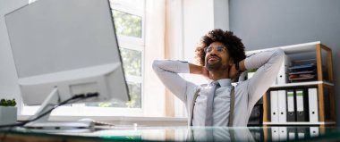 Başarılı Afrikalı iş adamı geriye yaslanıyor. Mutlu Çalışanlar