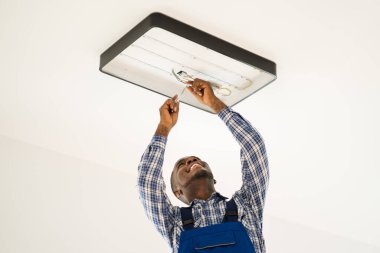 Afrikalı Bakım Elektrikçisi Merdiven Tamir ve Yükleme Işığı