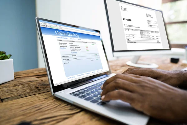 Young Businessman Looking Invoice While Doing Online Banking Computer — Stock Photo, Image