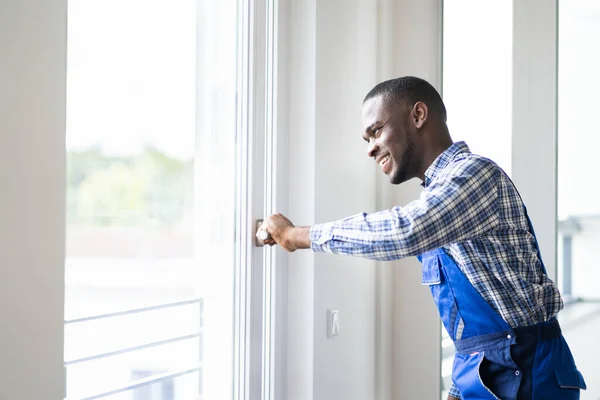 Joven Reparador Africano Overol Instalando Ventana —  Fotos de Stock