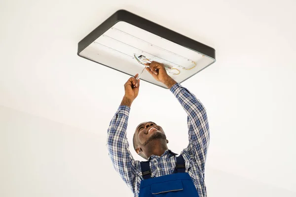 Eletricista Manutenção Africano Escada Fixação Instalação Luz — Fotografia de Stock