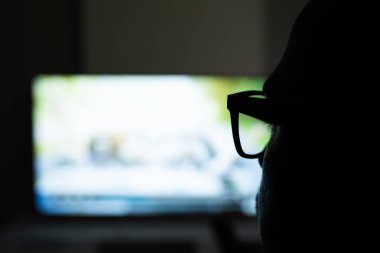 TV izlemek için Büyüteç Kullanan Adam 