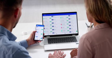 İş başvurusu için cep telefonu ve dizüstü bilgisayar kullanan adam