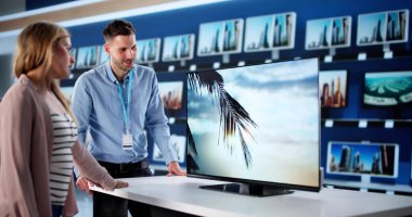 Mağazadaki Elektronik Bölümü 'nde Dizüstü bilgisayar fiyatlarını karşılaştıran kadın.