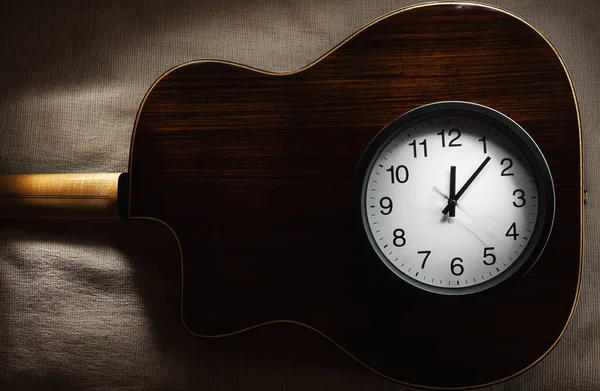 简单的构图 黑色的挂钟在床上毯子显示十二点和旧的复古吉普赛风格的一部分 声学吉他 — 图库照片