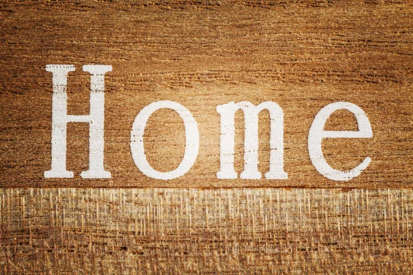 Word Home printed on a wooden plank.