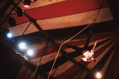 Sahne bir sirk gönderen oynamak, bulanıklık, ipin üzerinde bir kadın acrobat ışık reflektör odak ile. 