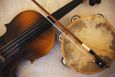 Details of an old and dusty violin from Czechoslovakia and tambourine.  clipart