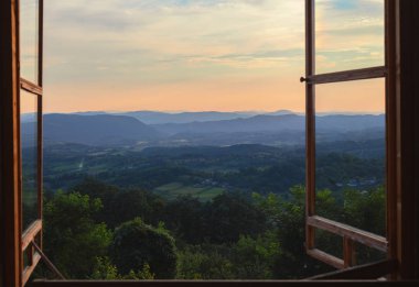 Köy Sırbistan, üzerinde eski pencereden yaz sezonunda günbatımı ile ilgilenen. 