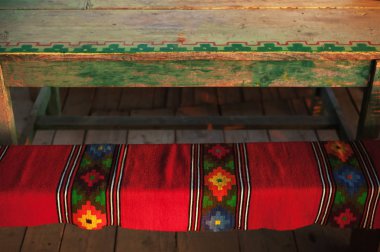 Bir ahşap Bank, Sırbistan yapımı ev yapımı bir halı dekorasyonu. Geleneksel köy yaşam tarzı. 