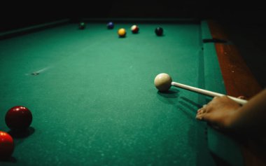 Bir oyuncu bir sonraki hamlesini bir gece barında büyük bir bilardo masasında yapmaya hazırlanıyor..