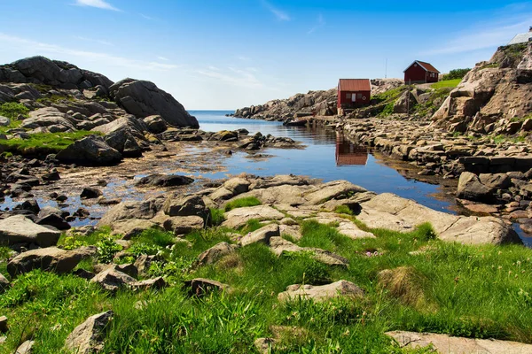 Landscape with red house near Lindesnes, Norway. The coast of southern Norway with an ocean view, rocky sea coast, South Norway, Lindesnes Fyr beacon.