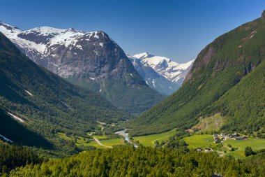 Norveç, yatay, yeşil vadi ve Dağları kar zirveleri ile arasında küçük bir köy. Doğa ve seyahat arka plan. Jostedalsbreen Milli Parkı, Batı Norveç.