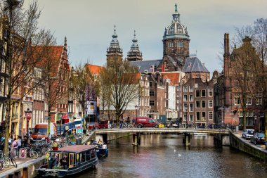 Amsterdam, Hollanda - 10 Nisan 2018: St. Nicholas Kilisesi ve Amsterdam kanal ile tipik Hollanda ev sahipliği yapmaktadır. Aziz Nikolaos Kilisesi kentin birincil Roma Katolik Kilisesi olduğunu.