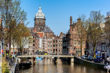 Amsterdam, Hollanda - 11 Nisan 2018: St. Nicholas Kilisesi ve Amsterdam kanal ile tipik Hollanda ev sahipliği yapmaktadır. Aziz Nikolaos Kilisesi kentin birincil Roma Katolik Kilisesi olduğunu.