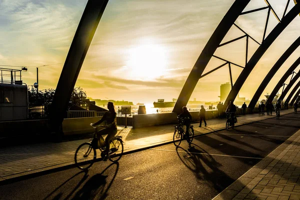 Felismerhetetlen Kerékpárosok Kerékpározás Naplementekor Amszterdami Pályaudvar Sziluettek — Stock Fotó