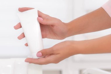 El Cilt Bakımı. Krem tüp tutan eller, eller güzel güzellik kadın yakın çekim ile doğal beyaz arka plan üzerinde. Çivi güzellik ve vücut kavram iyi bak. Sığ Dof.