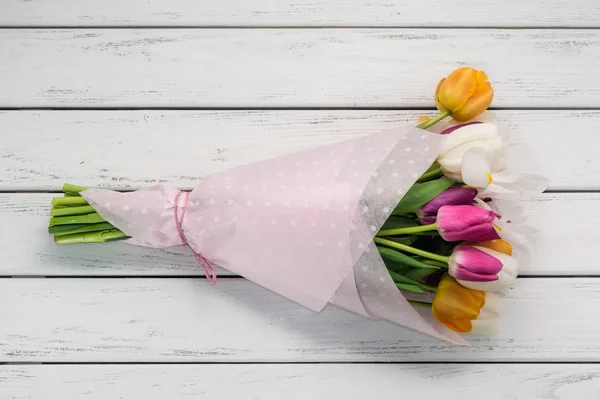 Букет Разноцветных Тюльпанов Бумажной Обертке Белом Деревянном Столе — стоковое фото