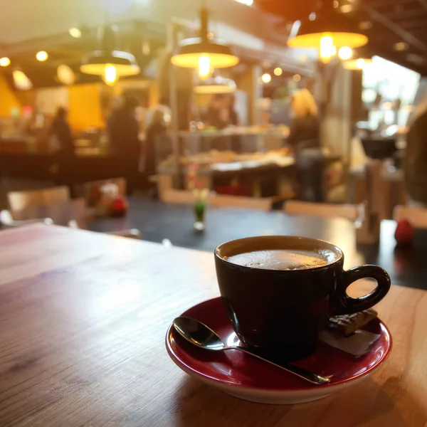 木製テーブルの上にコーヒー カップは コーヒー ショップの背景をぼかし コーヒー カップとソーサー木製のテーブル 暗い背景 カプチーノ 温かみのある黄色の照明 — ストック写真