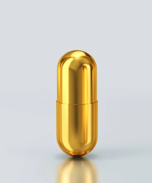 Zlatá kapsle pilulka izolované na šedém pozadí. Střihová cesta i — Stock fotografie