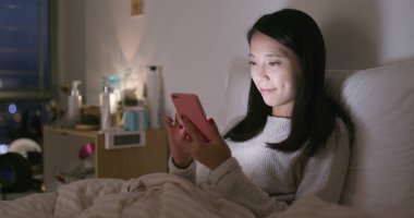 Kadın geceleri yatağa cep telefonu bak 