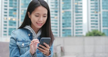 Şehirde akıllı telefon kullanan bir kadın