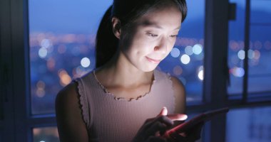 Cep telefonu evde akşamları kullanan kadın 