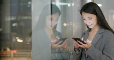 Pencere yansıması ile şehirde Smartphone kullanarak iş kadını