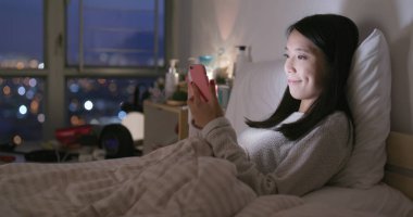 Evde akıllı telefon kullanan bir kadın. 