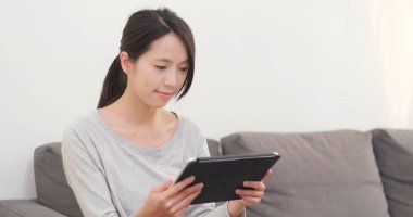 evde tablet bilgisayar kullanan kadın