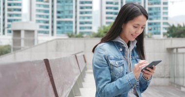 Online sosyal medya için cep telefonu kullanan genç kadın 