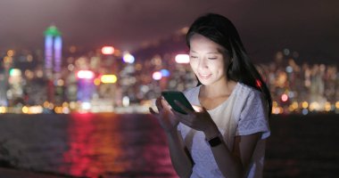 Kadın geceleri Smartphone cep telefonu ile Hong Kong şehrinde sesli mesaj gönderme