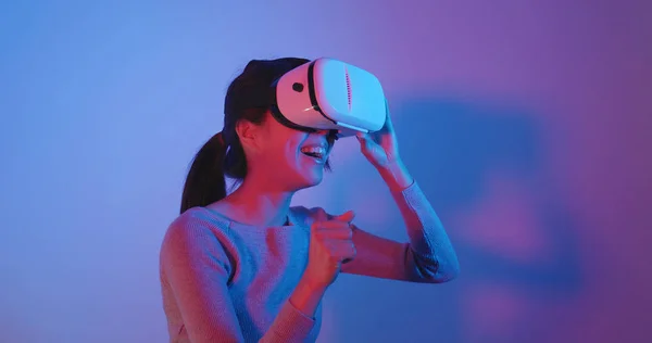 Woman looking though virtual reality device over red and blue light